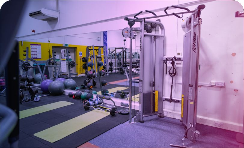 empty gym with varied exercise equipment and large mirrors