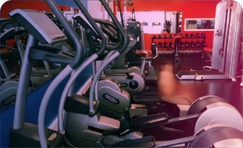 close up shot of cross trainers in a gym with weights in the background